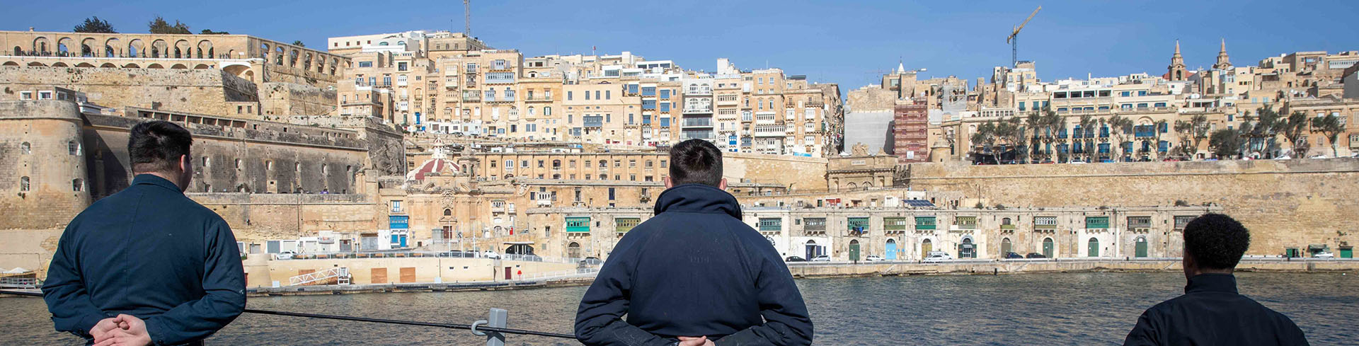 Sailors man the rails as a ship arrives in Malta